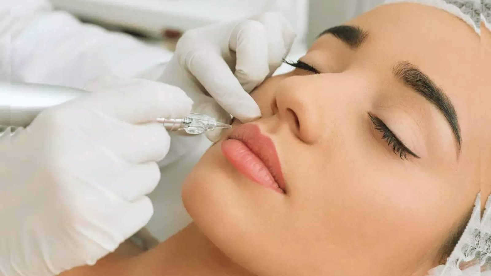 A woman undergoing a lip procedure with a machine, focused on enhancing her lips in a professional environment.