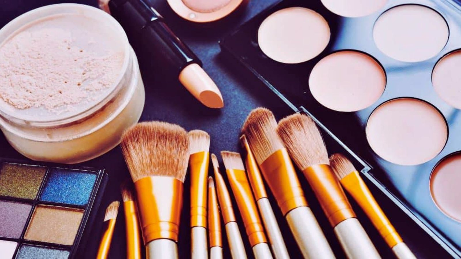 A collection of makeup brushes and various makeup products arranged neatly on a table surface.