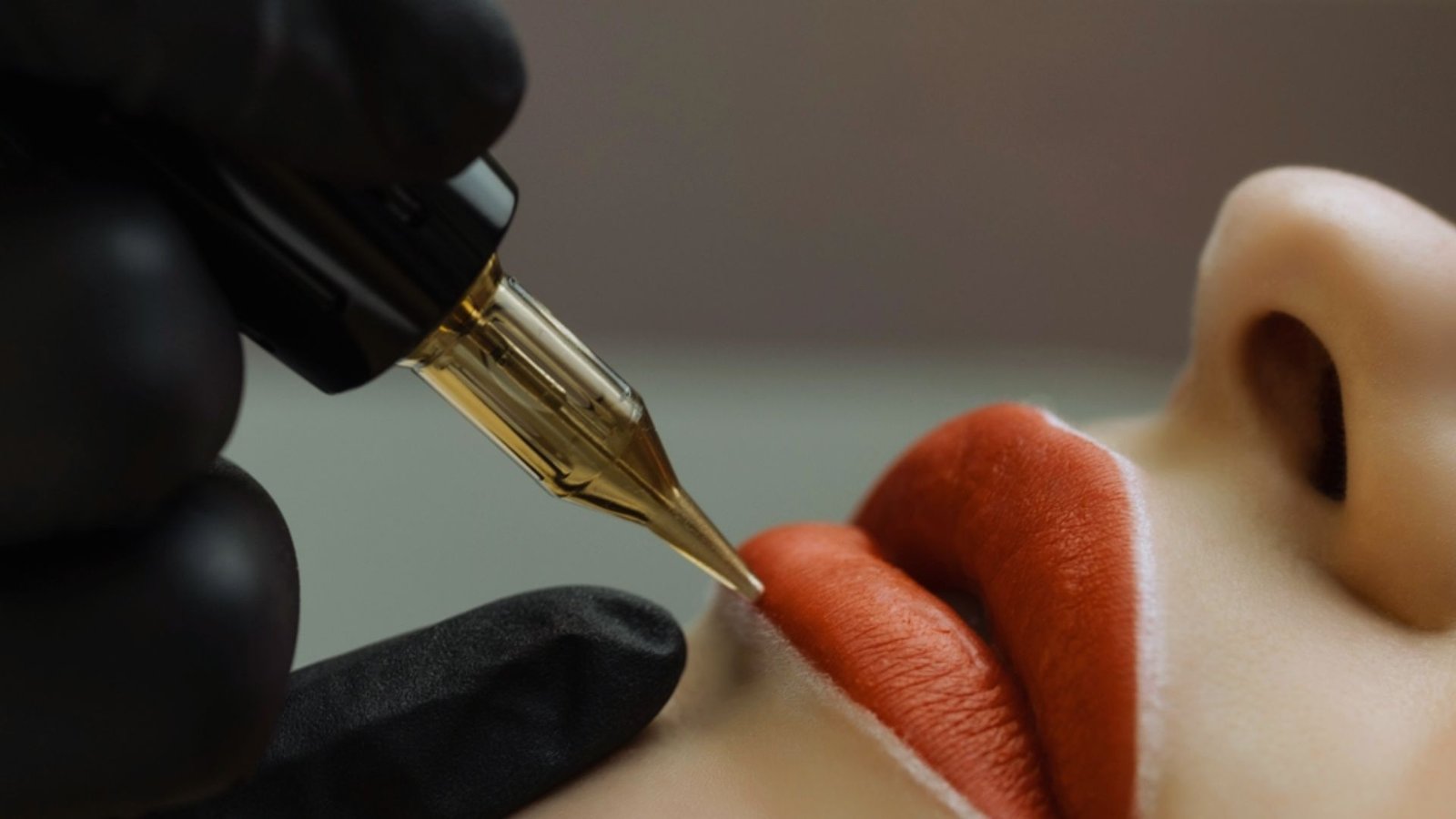 A woman receiving a lip tattoo using a pen, focused on the procedure in a professional setting.