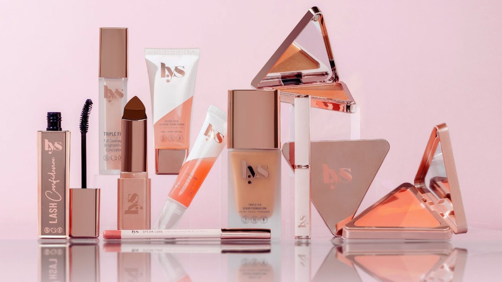 A triangle arrangement of various makeup products displayed on a flat surface.
