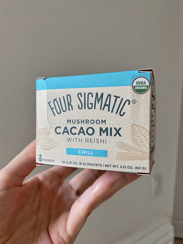 four sigmatic cacao mix against white wall