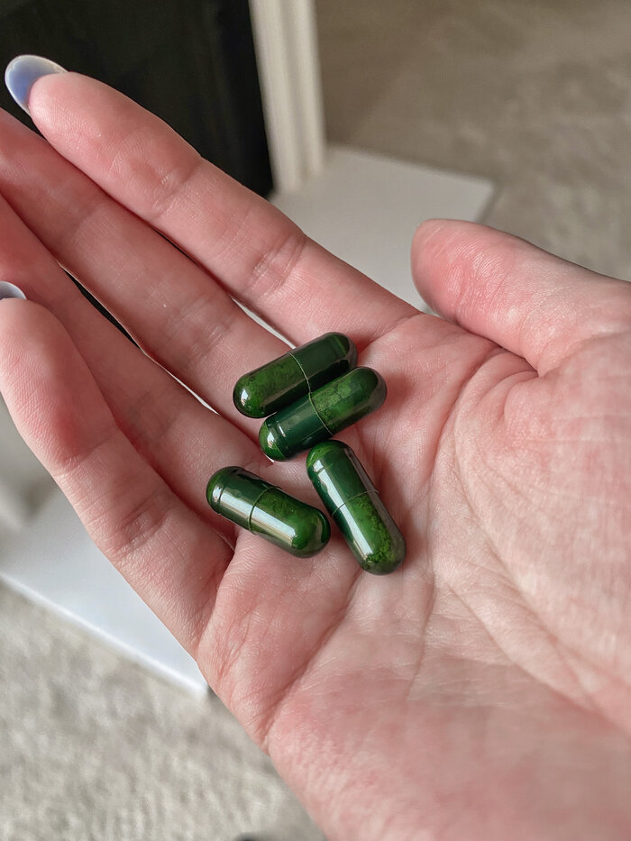 handful of green daily synbiotic capsules