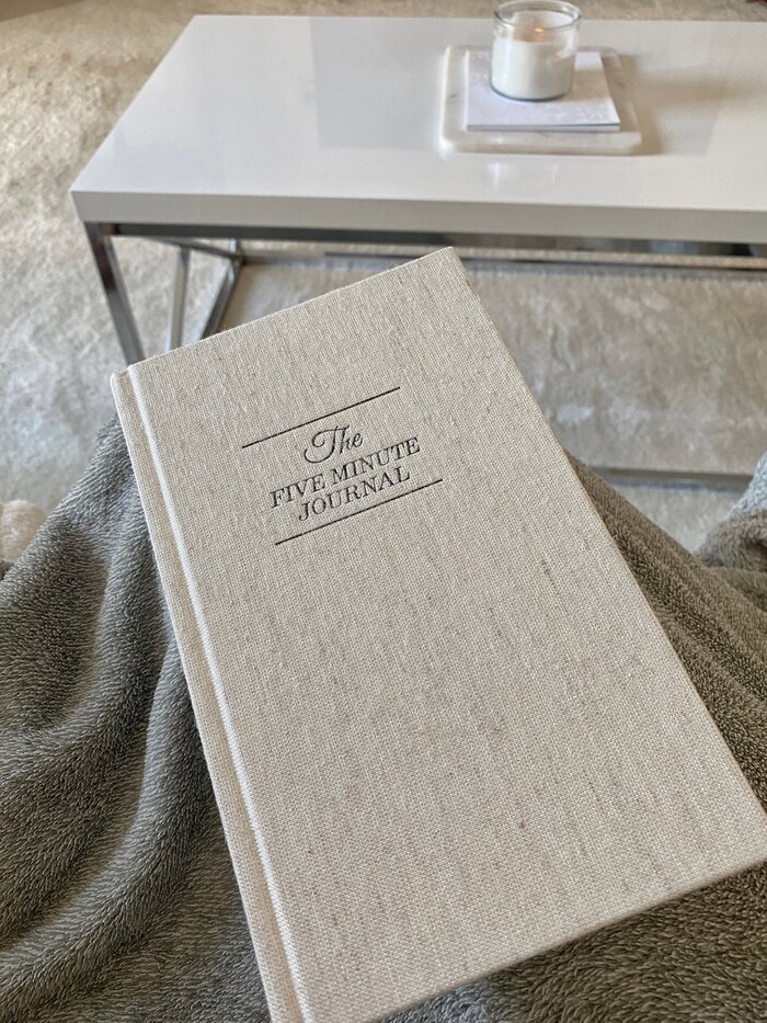 five minute journal next to coffee table