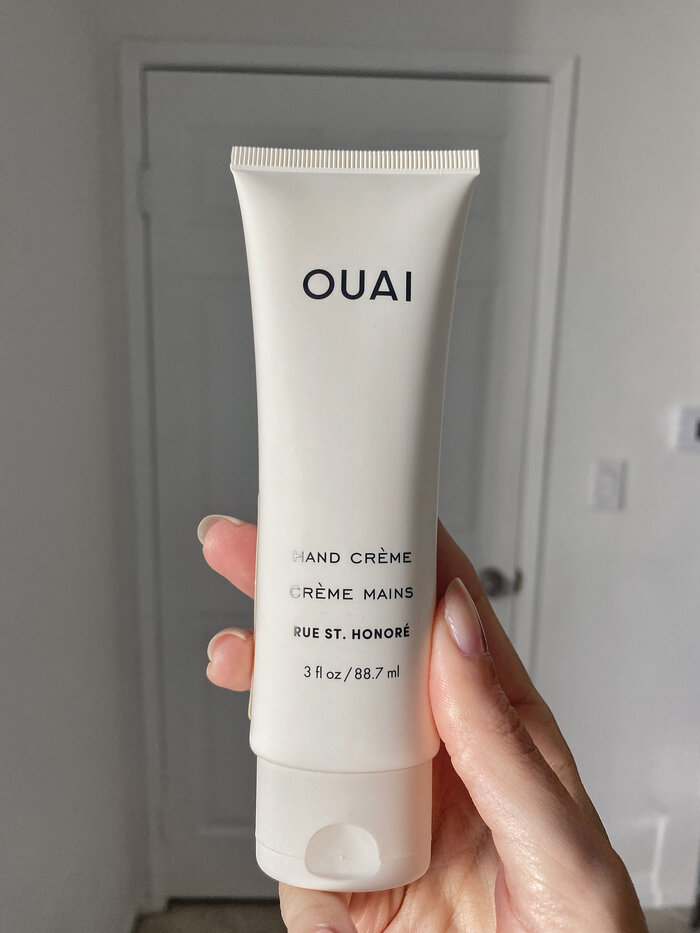 ouai hand creme against white wall