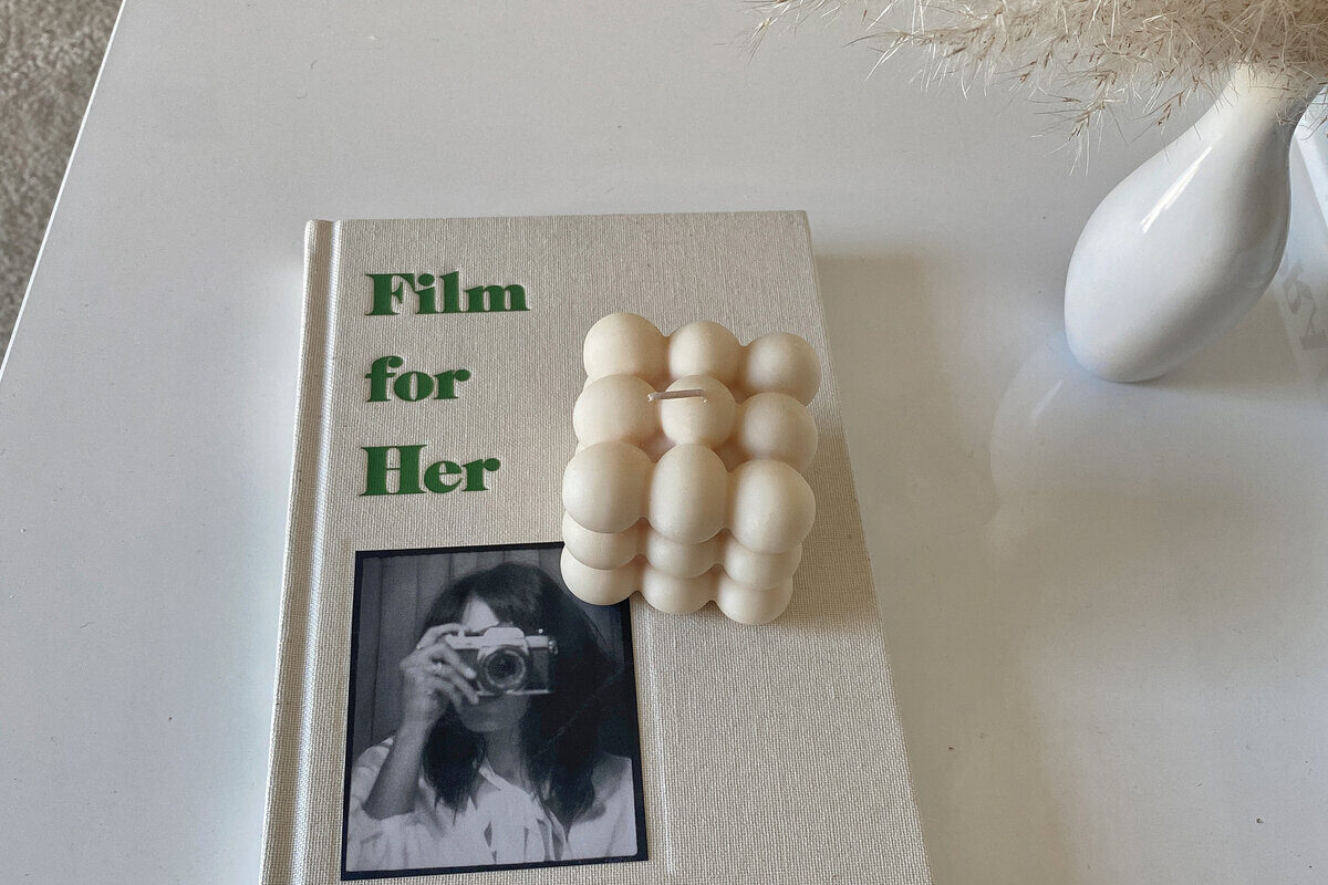 book and candle on white coffee table