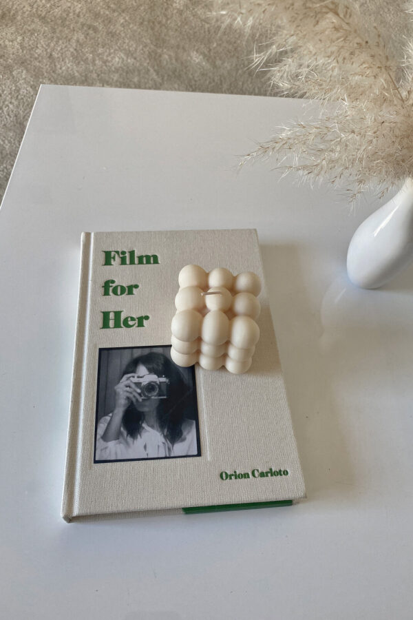 book and candle on white coffee table