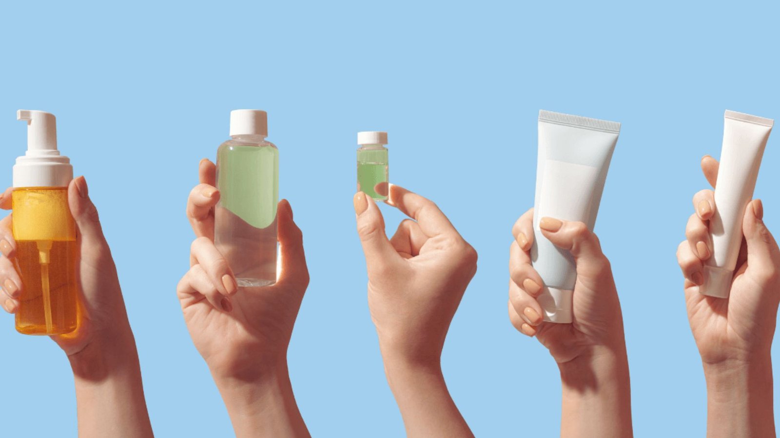 Hands displaying various skin care products, including creams, serums, and lotions, against a neutral background.