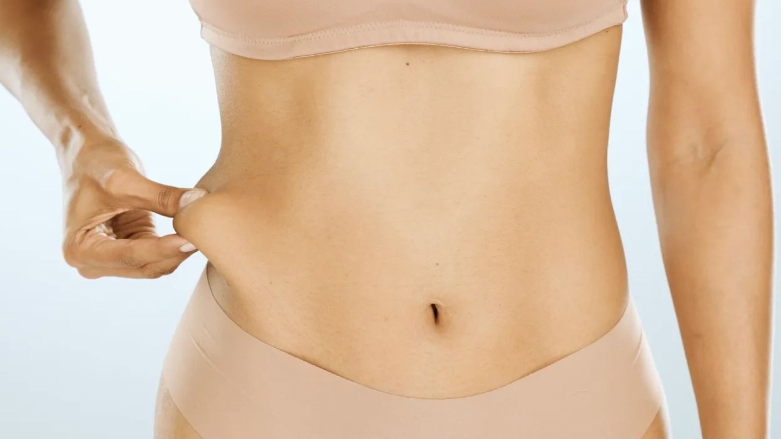 A woman wearing a bikini top and panties poses confidently, showcasing a summer beach style.