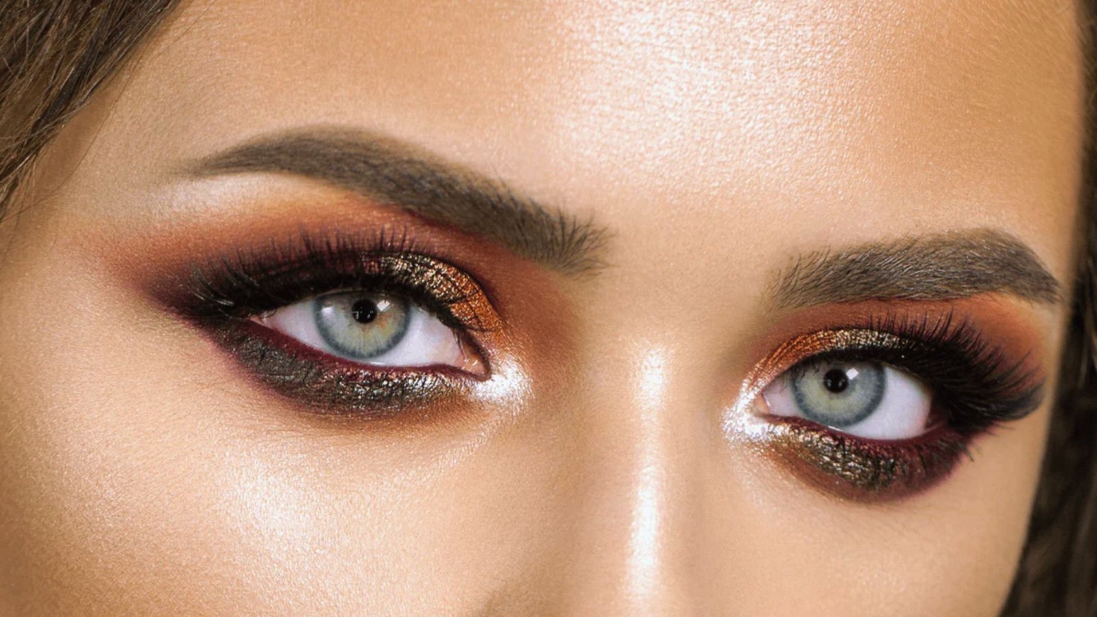 A woman with bright eyes and expertly applied makeup, showcasing her vibrant and expressive features.