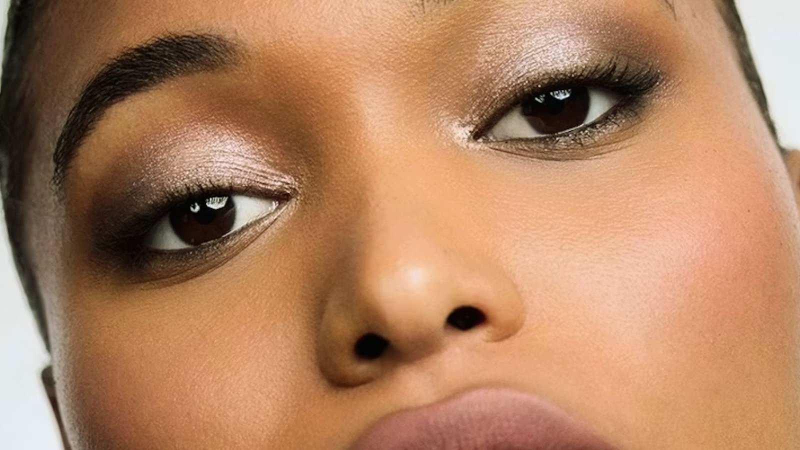 Close-up of a woman’s face highlighting her brown eye, showcasing her features and expression.