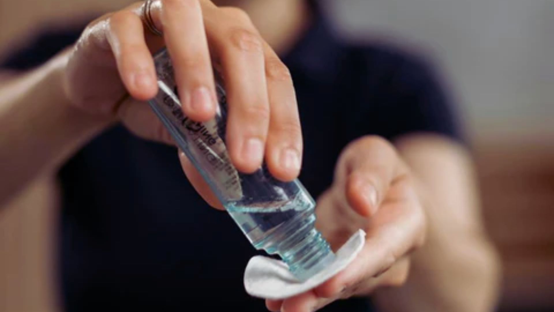 A person holds a bottle of hand sanitizer, ready to use it for hygiene purposes.