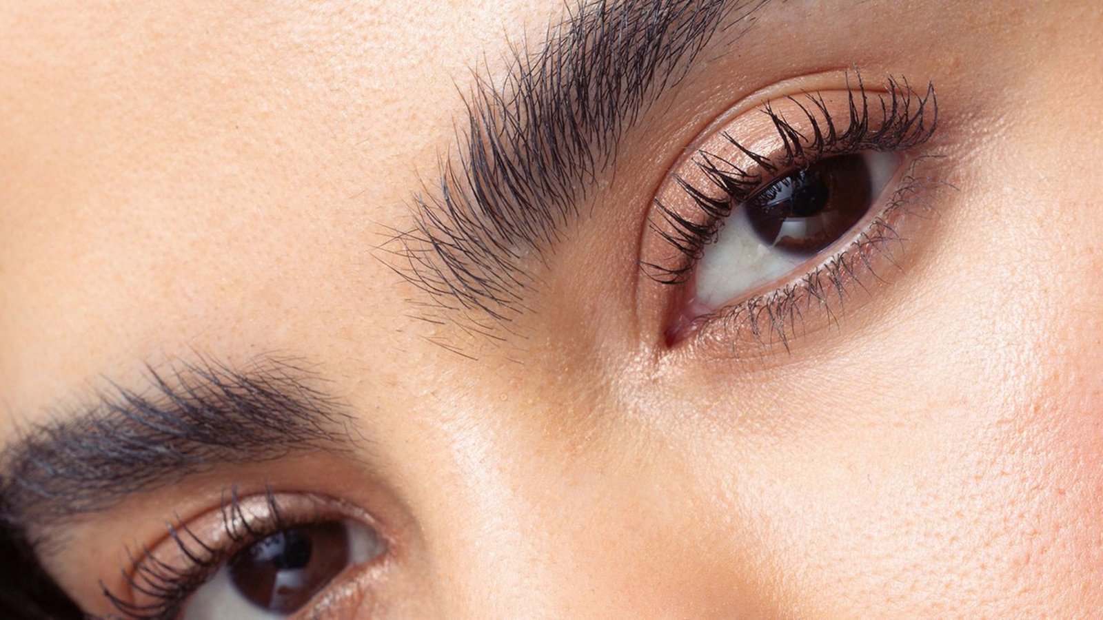 Close-up of a woman's eyes, showcasing their color and expression with a soft focus on the eyelashes.