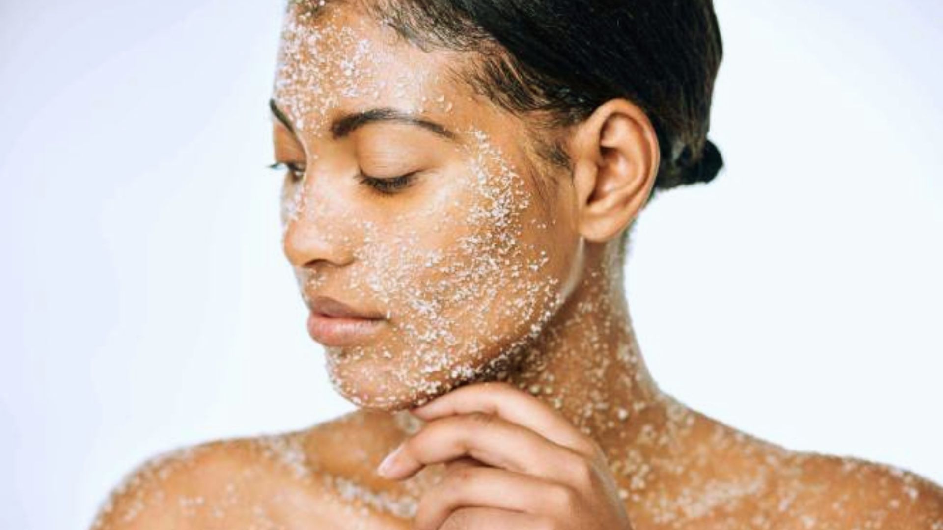 A woman with a white powder on her face, possibly for makeup or theatrical purposes, looking directly at the camera.