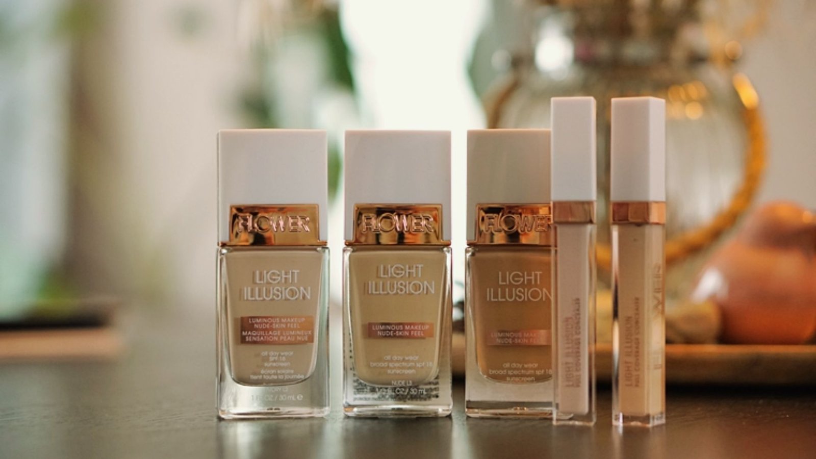 Four types of makeup products displayed on a table, including lipstick, foundation, eyeshadow, and mascara.