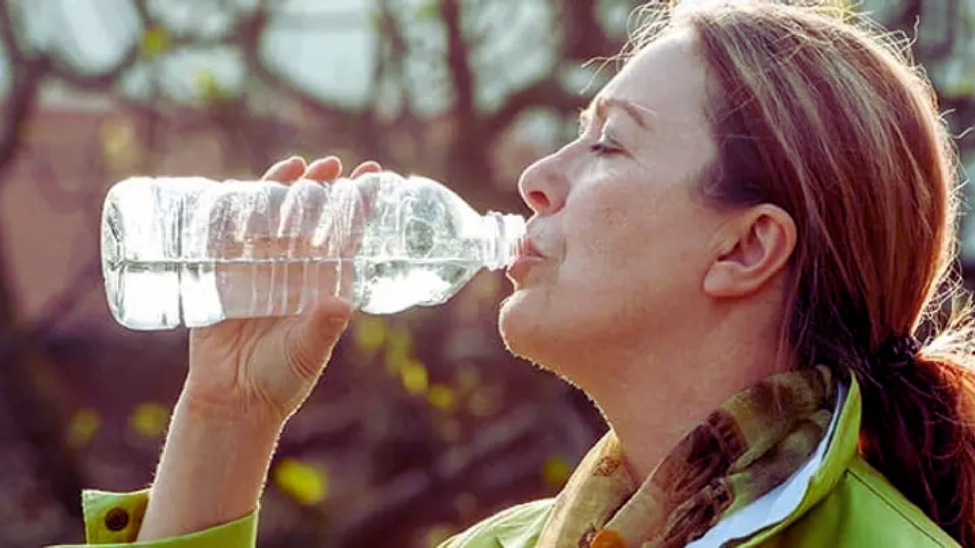 A woman takes a sip from a water bottle, staying hydrated during her activity.