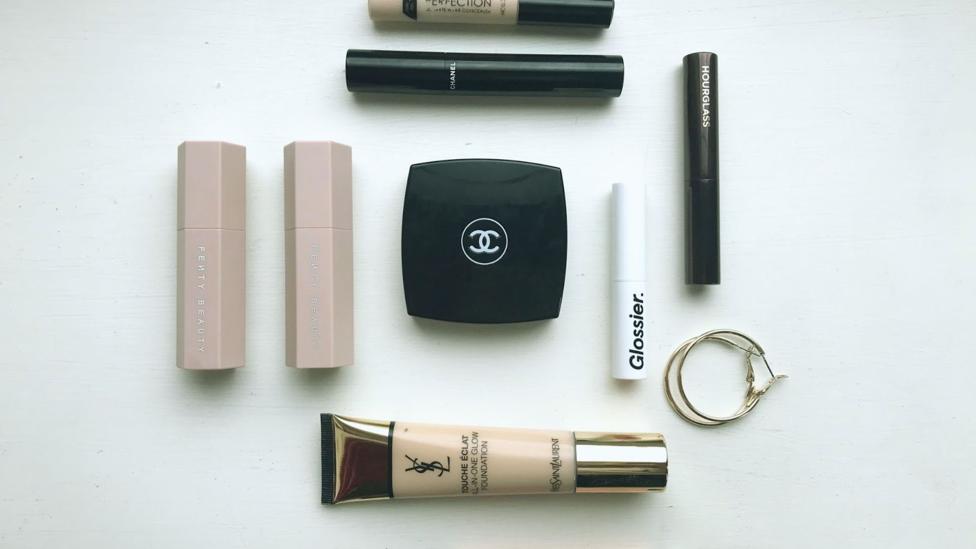 A Chanel makeup bag filled with various Chanel cosmetics, including lipsticks, mascara, eye shadow, and eyeliner.