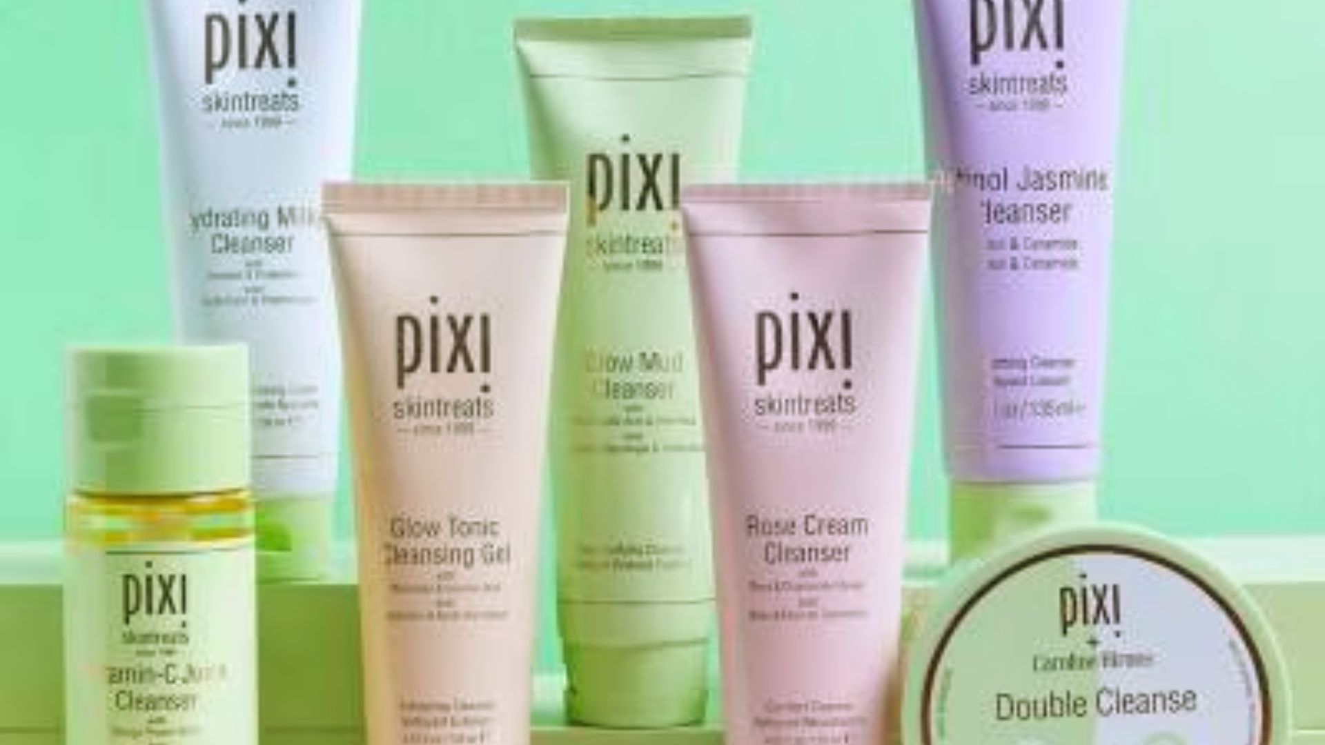 A variety of Pixi products arranged neatly on a vibrant green surface.