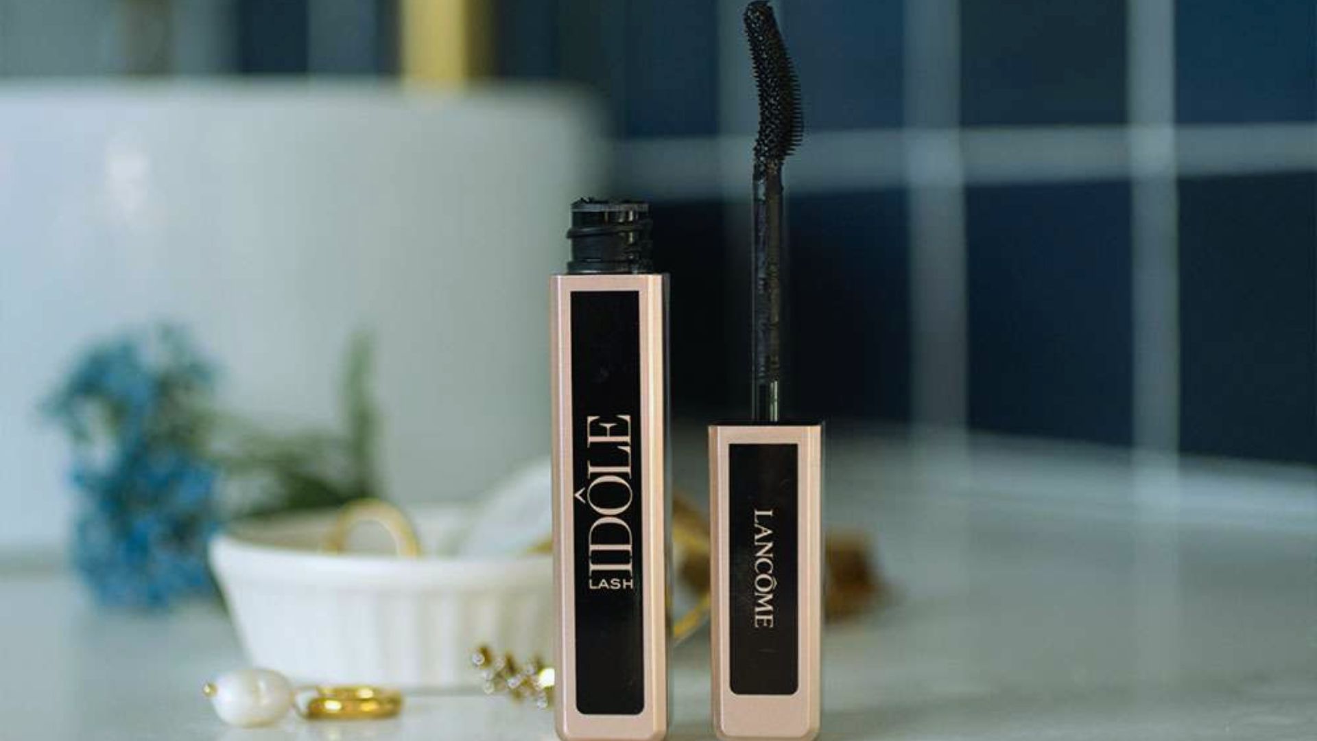 A mascara tube and brush placed neatly on a counter, showcasing beauty products for makeup application.