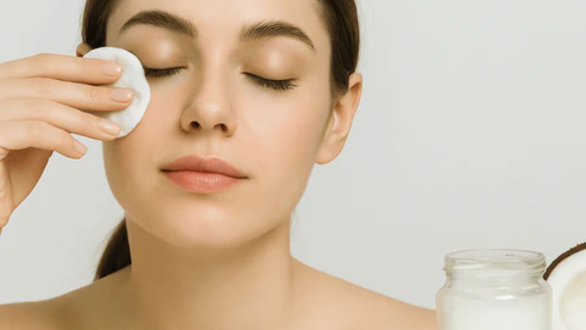 A woman cleans her face using a facial sponge, demonstrating a skincare routine.
