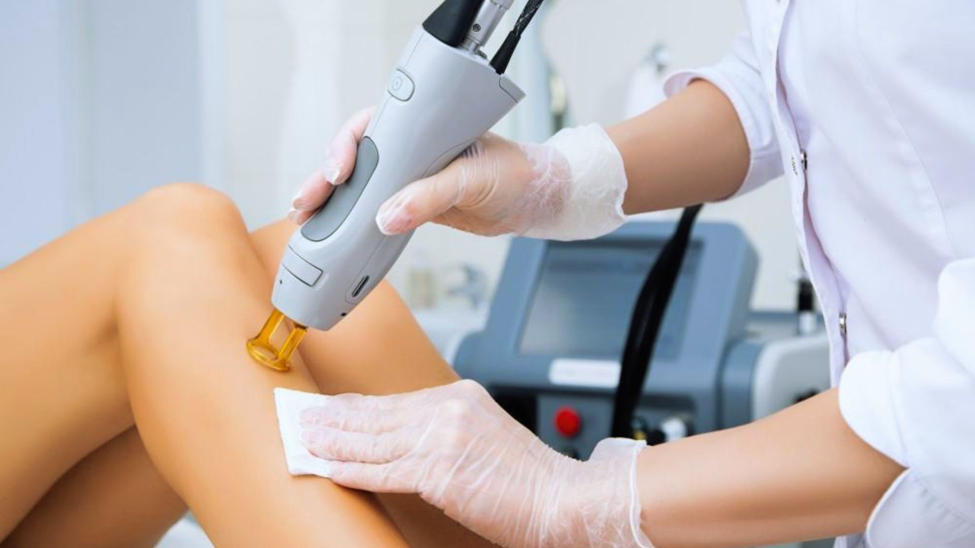 A person receiving laser treatment on their leg in a clinical setting, focused on skin care and hair removal.