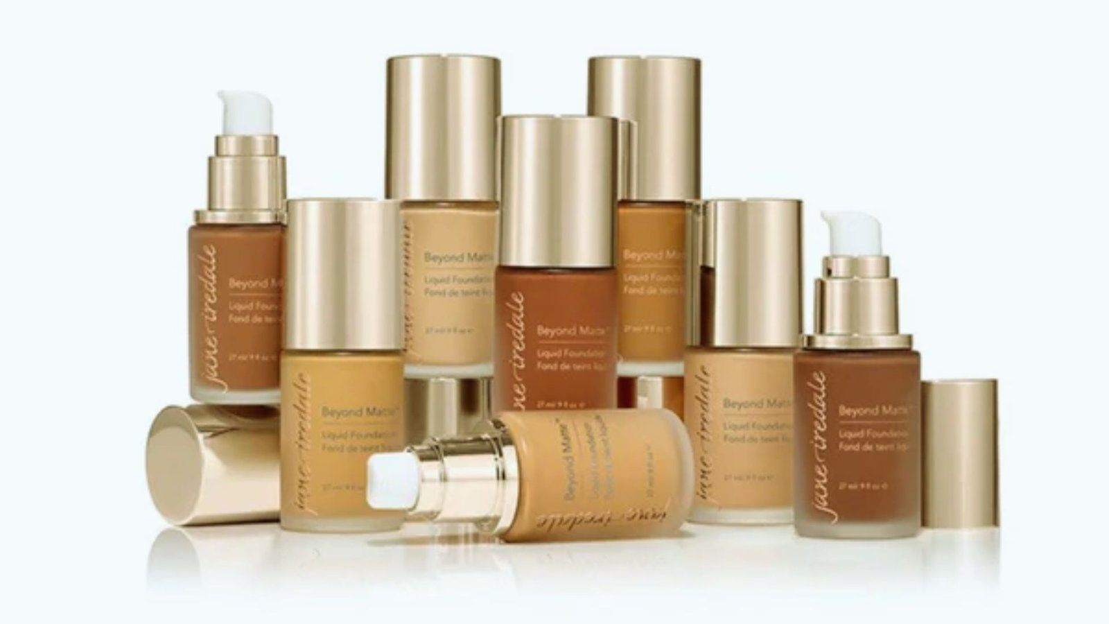 A close-up of a foundation bottle labeled "Best Foundation for Oily Skin" on a vanity with makeup brushes and a mirror.