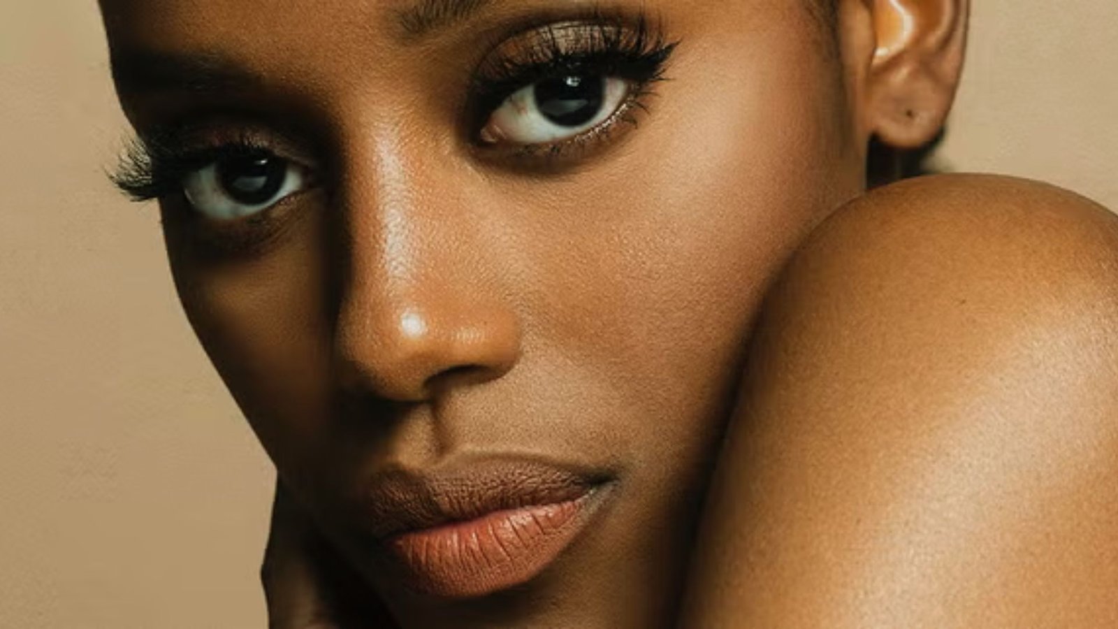 Close-up of a black woman showcasing vibrant makeup, highlighting her features and artistic expression.