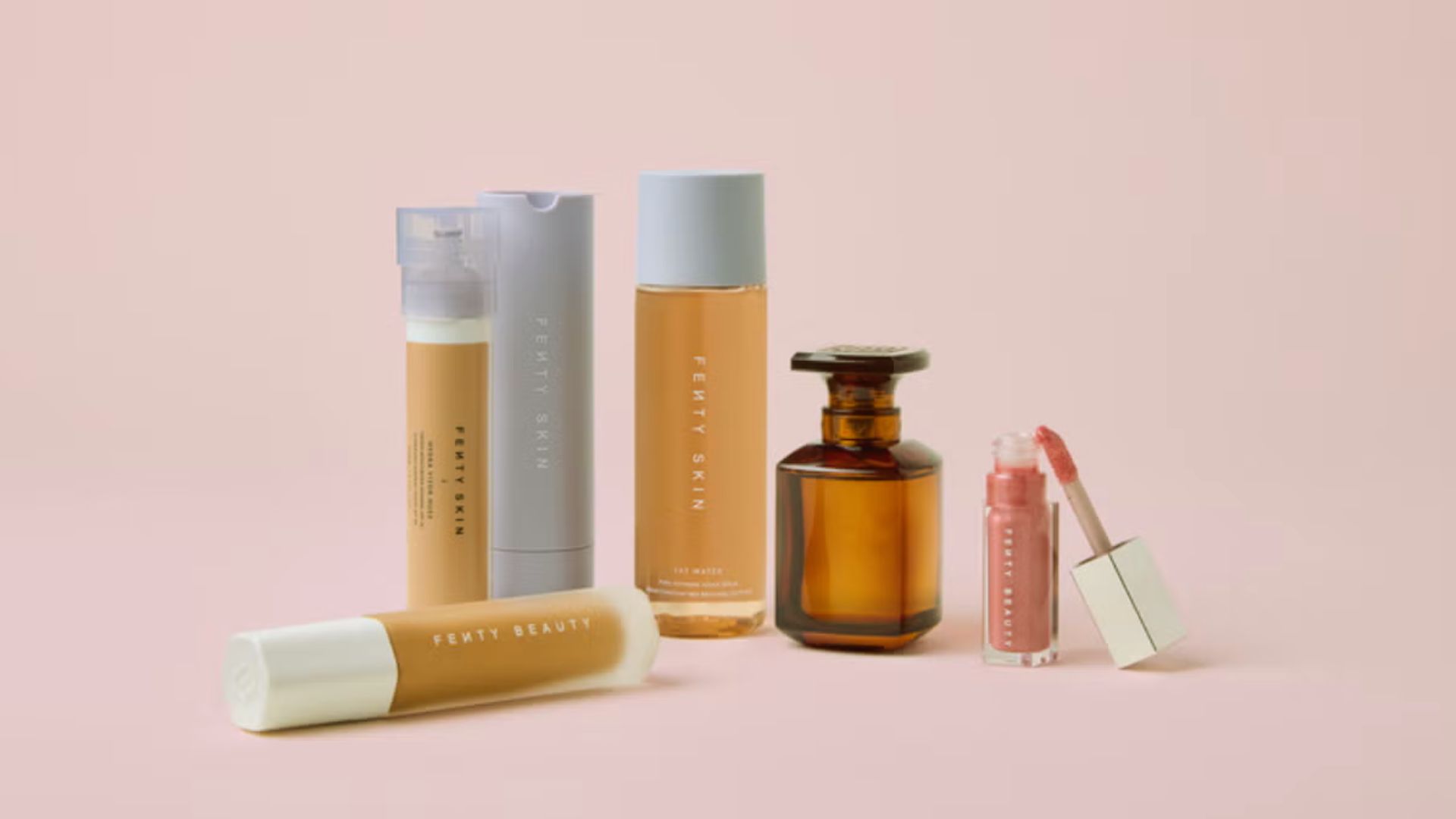 A collection of various beauty products displayed, including skincare, makeup, and fragrances in elegant packaging.