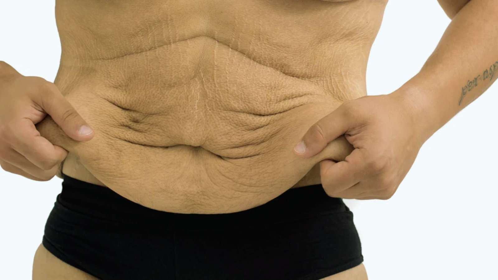 A man with a large belly proudly displaying his toned abs, showcasing a contrast between his physique and fitness goals.