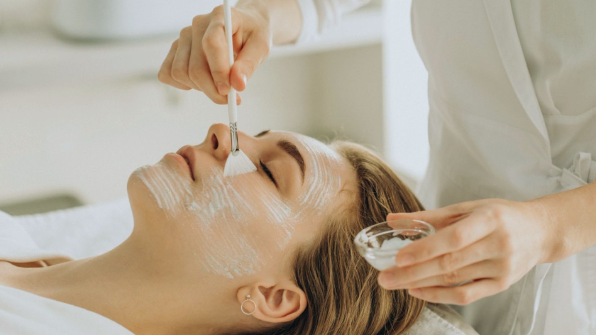 A woman receiving a facial treatment while relaxing in a serene spa environment.